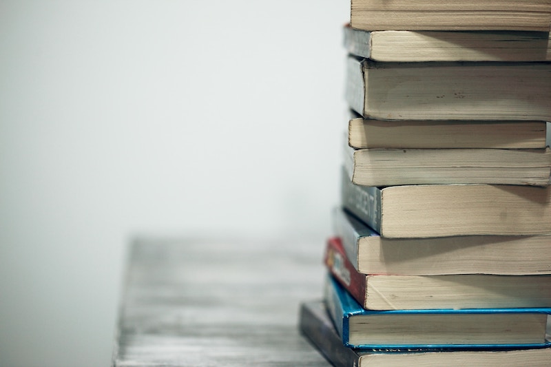 This is a photo of a stack of books on a desk showcasing the top 10 books entrepreneurs should read.